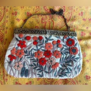 Vintage clutch, features French knot flowers and gold thread outline stitching.